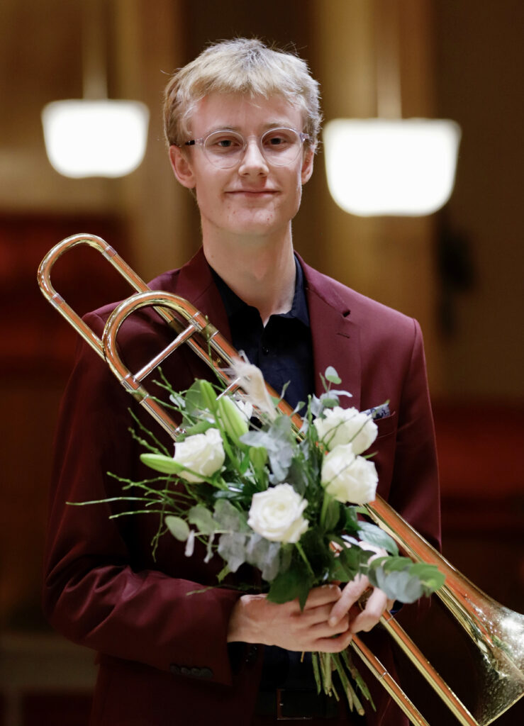 Lukas Flink, vinnare står med sitt instrument och blombukett
